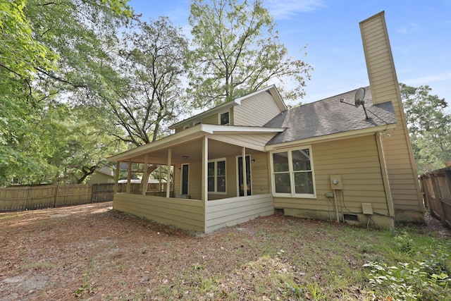 123 Lewisfield Dr, North Charleston, SC 29418 - rear view of house featuring a chimney, fence, roof with shingles, and a sunroom