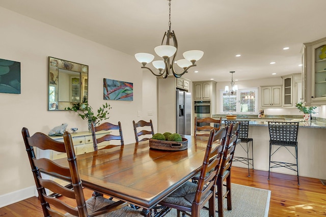 dining room with light hardwood / wood-style floors and a chandelier