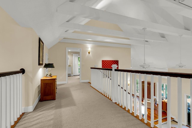 hall featuring lofted ceiling with beams and light colored carpet