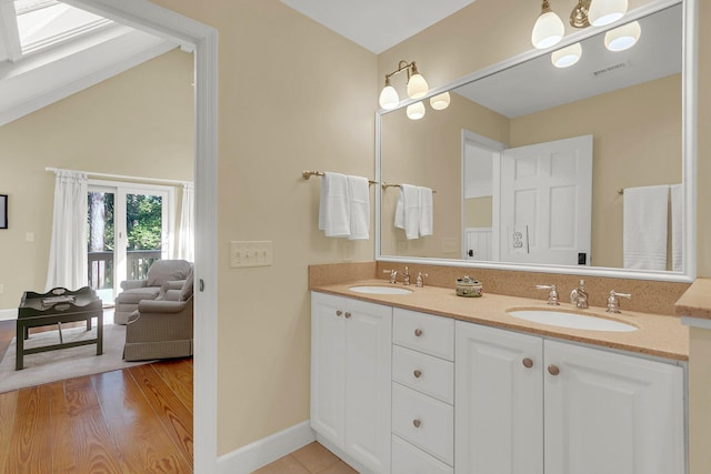 bathroom featuring vanity, a skylight, and hardwood / wood-style flooring