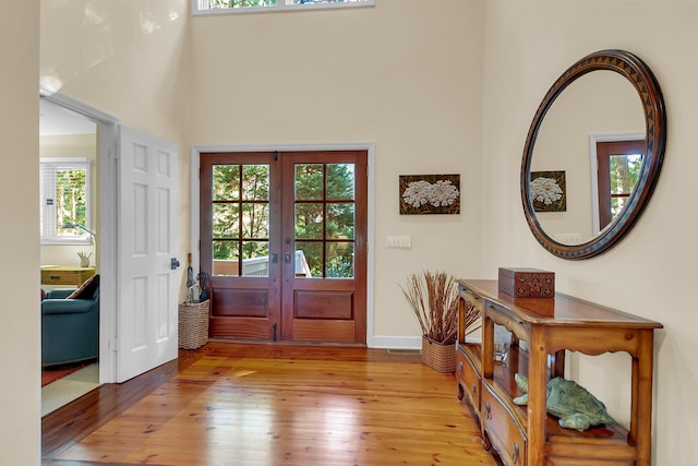 entrance foyer with french doors and light hardwood / wood-style flooring