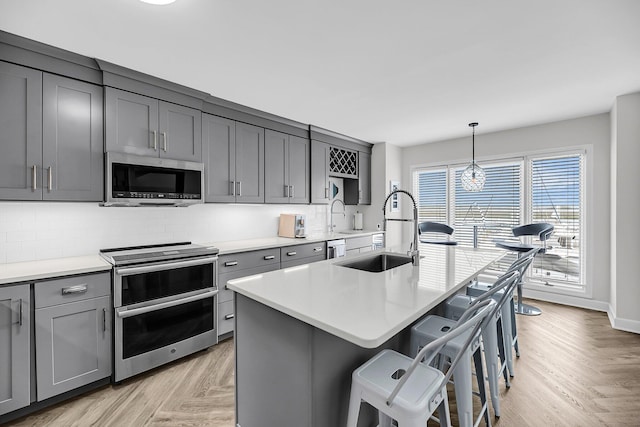 1948 Marsh Oak Ln, Seabrook Island, SC 29455 - kitchen with appliances with stainless steel finishes, a sink, gray cabinets, backsplash, and a breakfast bar