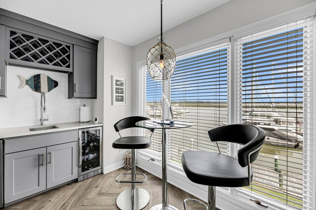 1948 Marsh Oak Ln, Seabrook Island, SC 29455 - bar featuring beverage cooler, a sink, baseboards, tasteful backsplash, and pendant lighting