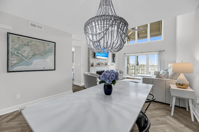 1948 Marsh Oak Ln, Seabrook Island, SC 29455 - dining space featuring a stone fireplace, baseboards, a towering ceiling, and a chandelier