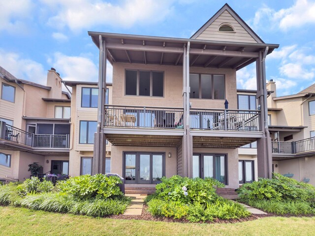 1948 Marsh Oak Ln, Seabrook Island, SC 29455 - rear view of house with stucco siding, a balcony, and french doors