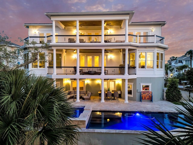 1720 Bowline Dr, Mount Pleasant, SC 29466 - back of property at dusk with a balcony, ceiling fan, an outdoor hangout area, a patio area, and an outdoor pool