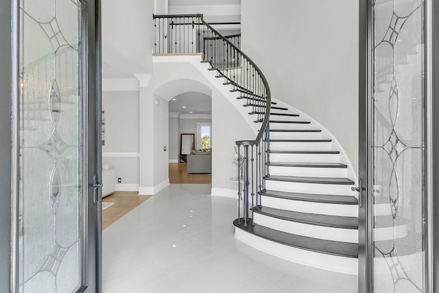 1720 Bowline Dr, Mount Pleasant, SC 29466 - entryway with arched walkways, a towering ceiling, stairs, tile patterned flooring, and baseboards