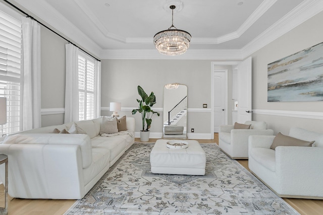 1720 Bowline Dr, Mount Pleasant, SC 29466 - living room featuring a chandelier, light wood finished floors, crown molding, a tray ceiling, and stairway