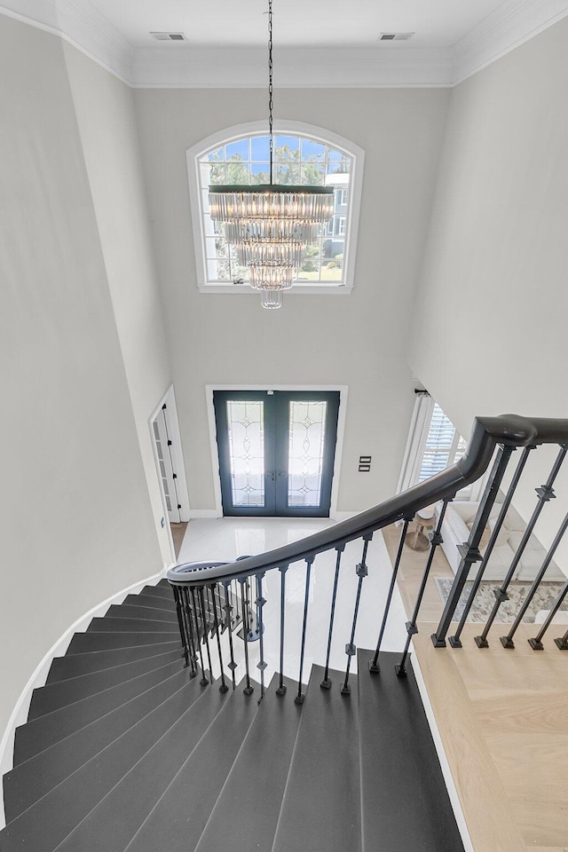 1720 Bowline Dr, Mount Pleasant, SC 29466 - stairway featuring french doors, a chandelier, baseboards, a towering ceiling, and crown molding