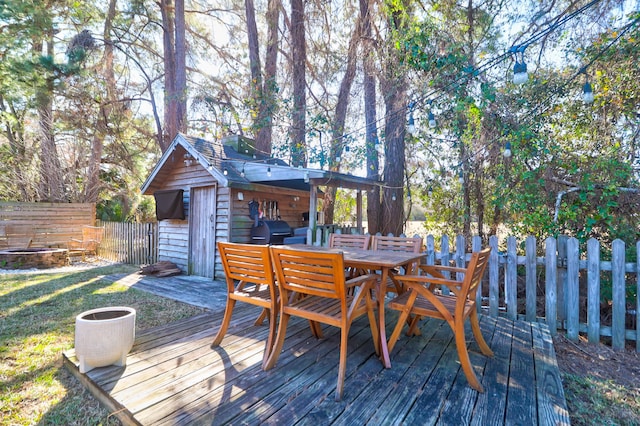 wooden terrace with grilling area and a storage shed