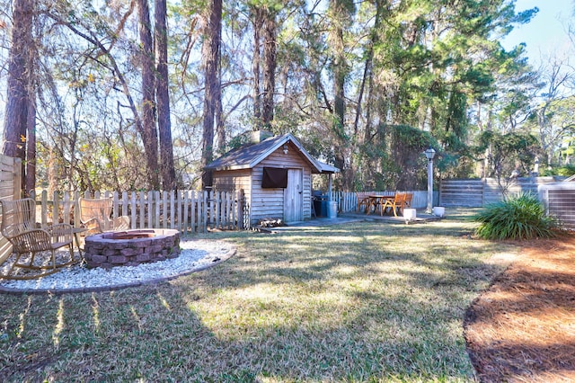 view of yard featuring an outdoor fire pit and a storage shed