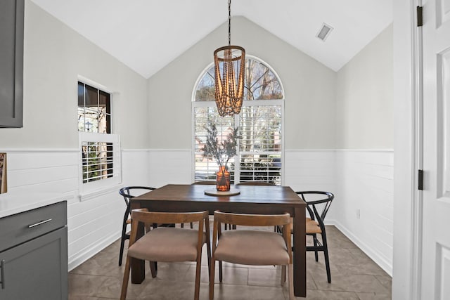 dining space featuring vaulted ceiling, tile patterned floors, and plenty of natural light