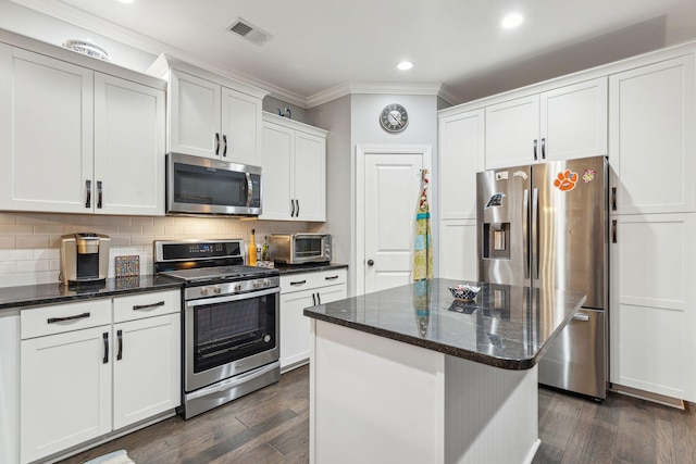 kitchen with visible vents, crown molding, dark wood-type flooring, decorative backsplash, and stainless steel appliances