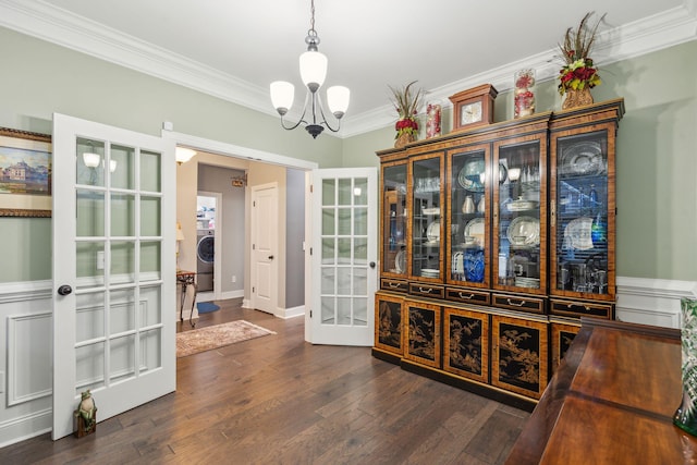 interior space featuring washer / dryer, dark wood-type flooring, french doors, crown molding, and a notable chandelier