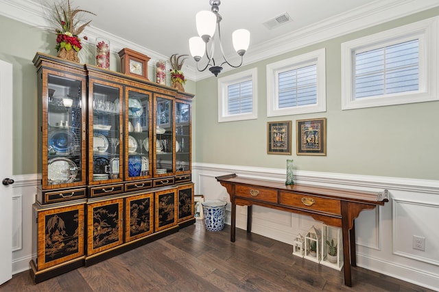 interior space with visible vents, dark wood finished floors, an inviting chandelier, ornamental molding, and wainscoting