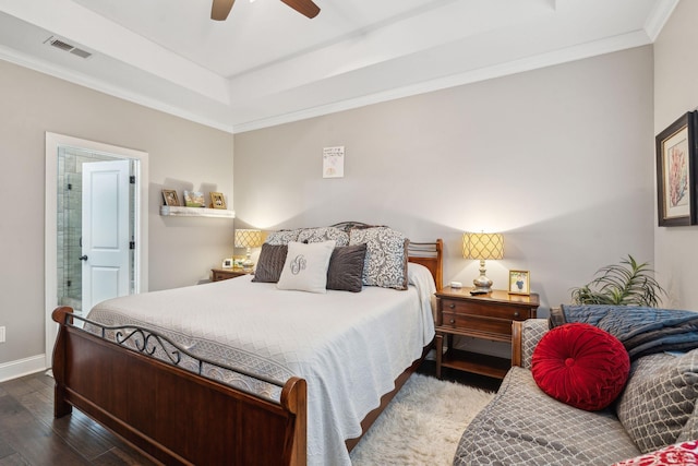 bedroom with visible vents, ornamental molding, hardwood / wood-style floors, connected bathroom, and baseboards