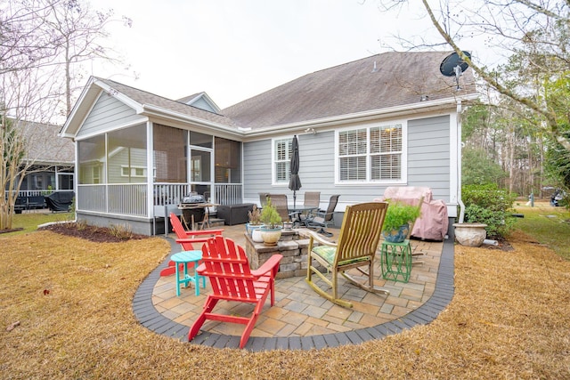 rear view of property featuring a sunroom, a lawn, a shingled roof, and a patio area