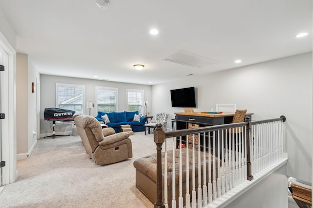 living area featuring light carpet, recessed lighting, attic access, and baseboards