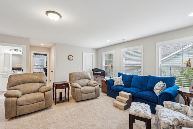 living area with light carpet and recessed lighting