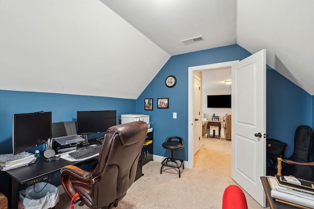 office space featuring lofted ceiling, light colored carpet, visible vents, and baseboards