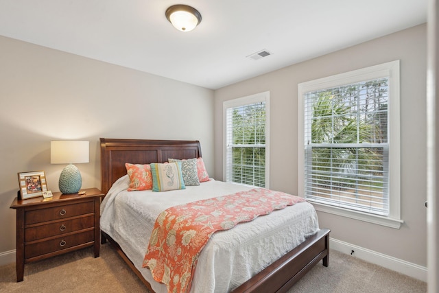 bedroom featuring light colored carpet, visible vents, and baseboards