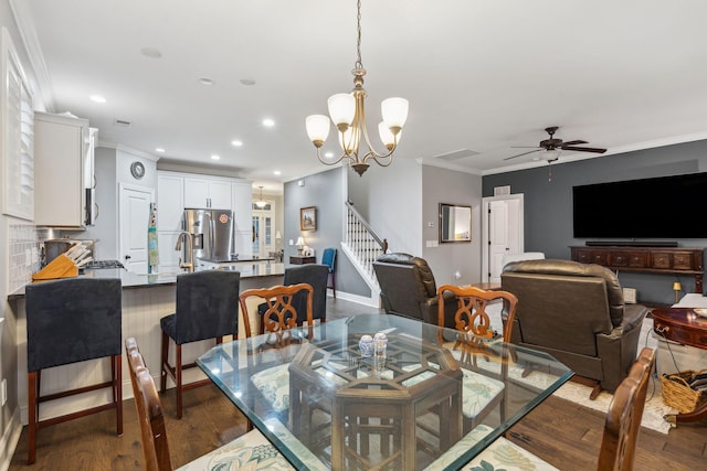 dining space featuring dark wood-type flooring, stairway, ornamental molding, recessed lighting, and ceiling fan with notable chandelier