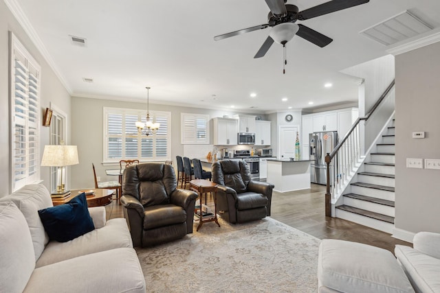 living area featuring visible vents, stairway, crown molding, and wood finished floors