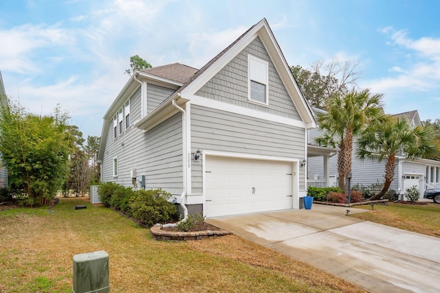 view of side of home featuring a lawn, concrete driveway, and an attached garage