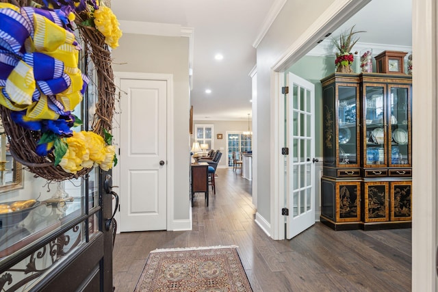 entrance foyer featuring crown molding, baseboards, dark wood-type flooring, recessed lighting, and a notable chandelier