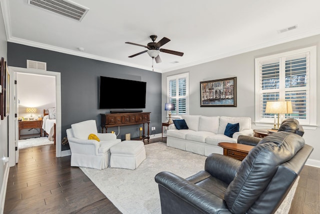 living room featuring dark wood-type flooring, a healthy amount of sunlight, and visible vents