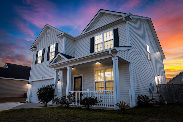 traditional-style house featuring an attached garage, driveway, fence, and a porch