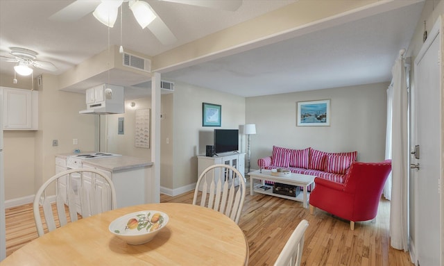 dining space featuring visible vents, baseboards, light wood-style floors, and a ceiling fan