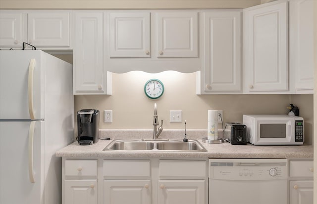 kitchen featuring white cabinets, white appliances, light countertops, and a sink