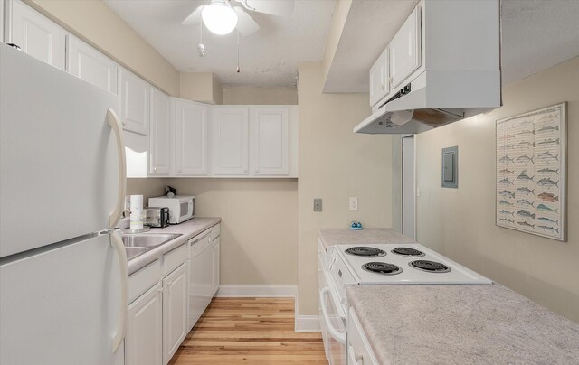 kitchen with white cabinetry, white appliances, light countertops, and light wood finished floors