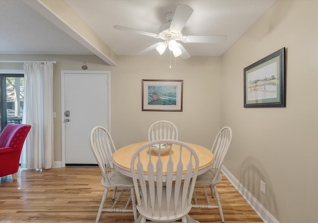 dining room featuring a ceiling fan, light wood-type flooring, and baseboards