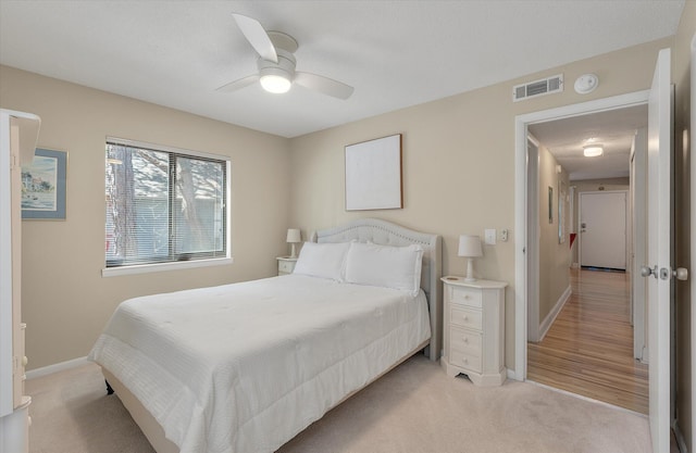 bedroom featuring ceiling fan, baseboards, visible vents, and light carpet