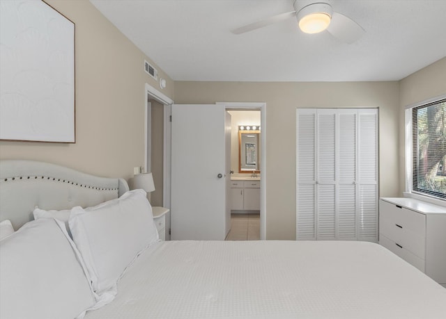 tiled bedroom featuring visible vents, a closet, ceiling fan, and ensuite bathroom