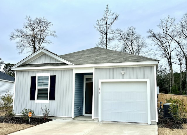 ranch-style home with central AC unit and a garage