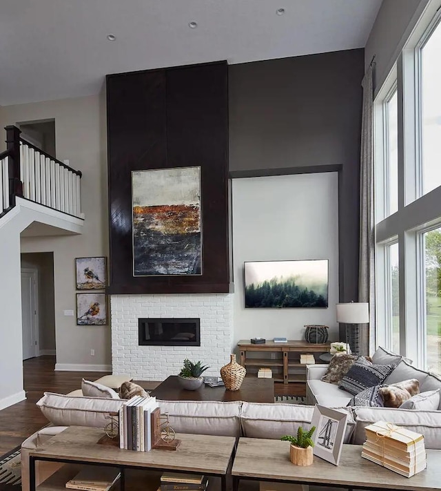100 Fish Rd, Ridgeville, SC 29472 - living area featuring baseboards, a fireplace, wood finished floors, and a towering ceiling