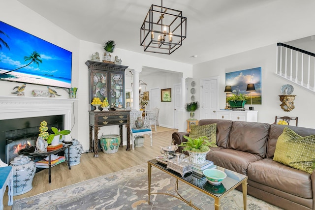 1682 Camfield Ln, Mount Pleasant, SC 29466 - living room with ornate columns, wood finished floors, a glass covered fireplace, and a chandelier