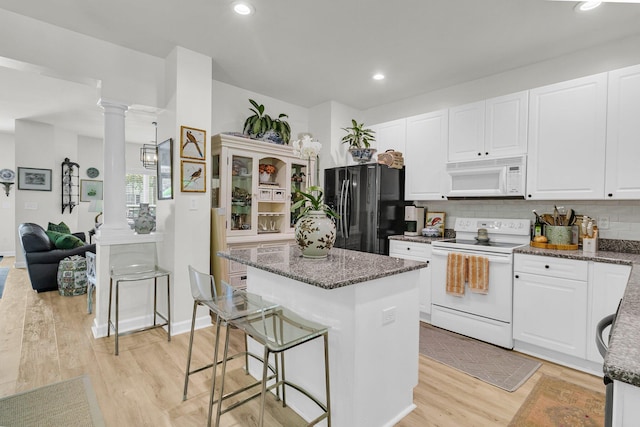 1682 Camfield Ln, Mount Pleasant, SC 29466 - kitchen with white appliances, a kitchen island, dark stone counters, light wood-style floors, and recessed lighting