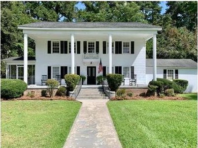 neoclassical home with a front lawn