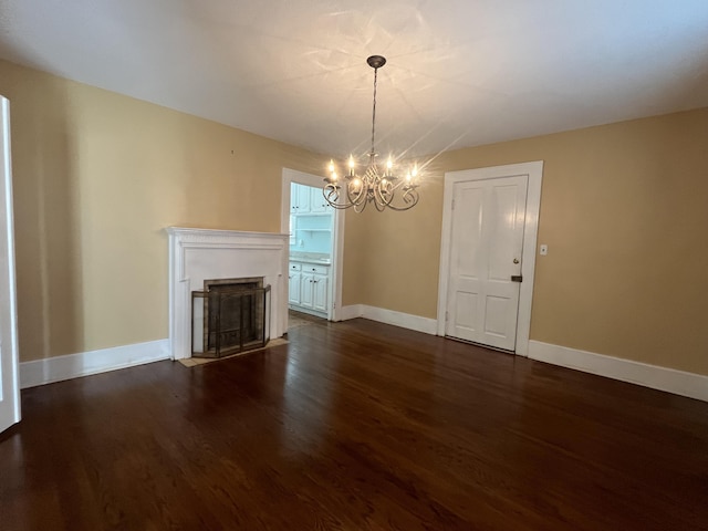 unfurnished living room featuring dark wood-type flooring and an inviting chandelier