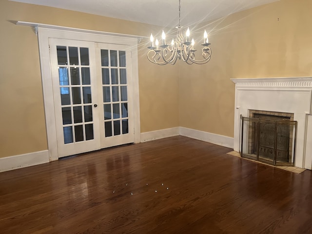 unfurnished living room with lofted ceiling, dark hardwood / wood-style floors, french doors, and a chandelier