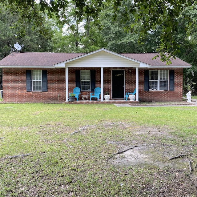 single story home featuring a porch, brick siding, a front yard, and roof with shingles