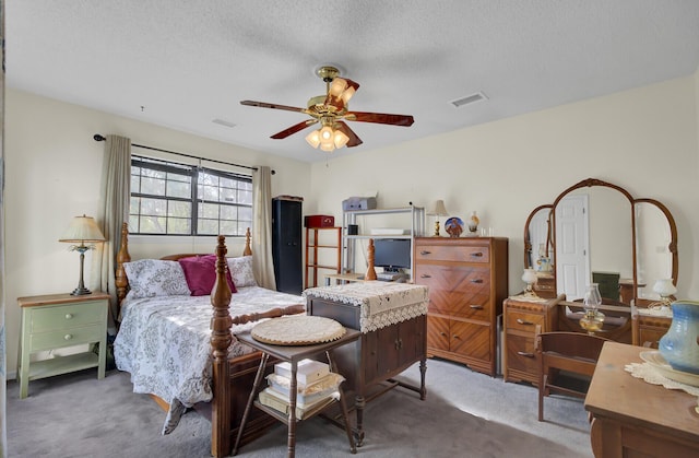 bedroom with ceiling fan, a textured ceiling, and dark carpet