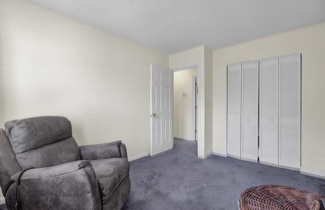 sitting room featuring dark colored carpet