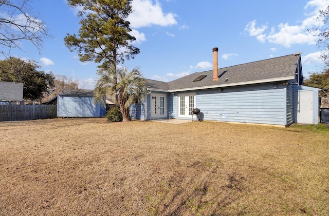 back of house with a storage shed, a lawn, and french doors