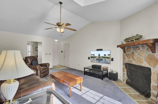 living room with ceiling fan, a fireplace, lofted ceiling with skylight, and light carpet