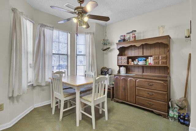 dining room featuring ceiling fan, carpet floors, and a textured ceiling